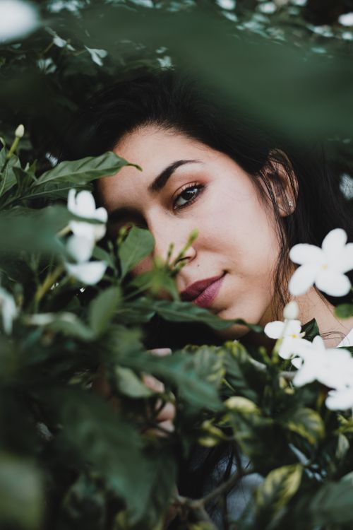 Free Captivating close-up of a woman surrounded by white jasmine flowers, evoking a serene and natural ambiance. Stock Photo