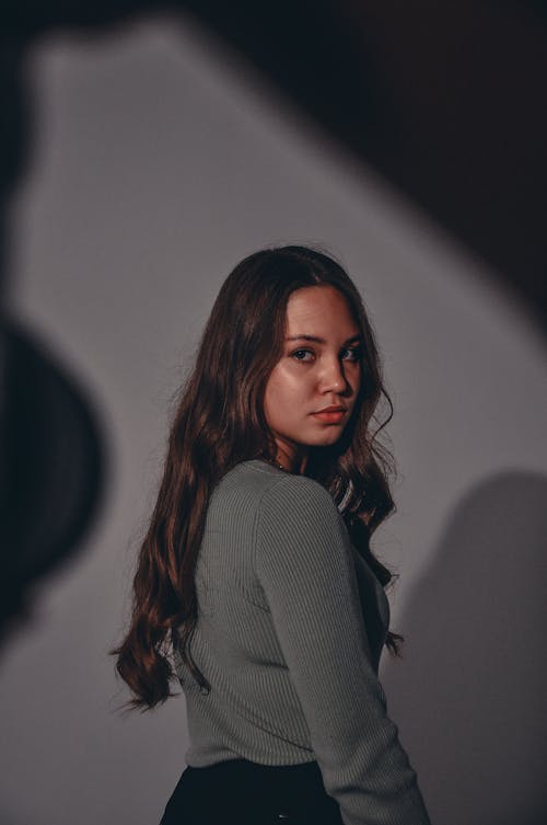 Woman in Gray Long Sleeve Shirt Looking Over Shoulder