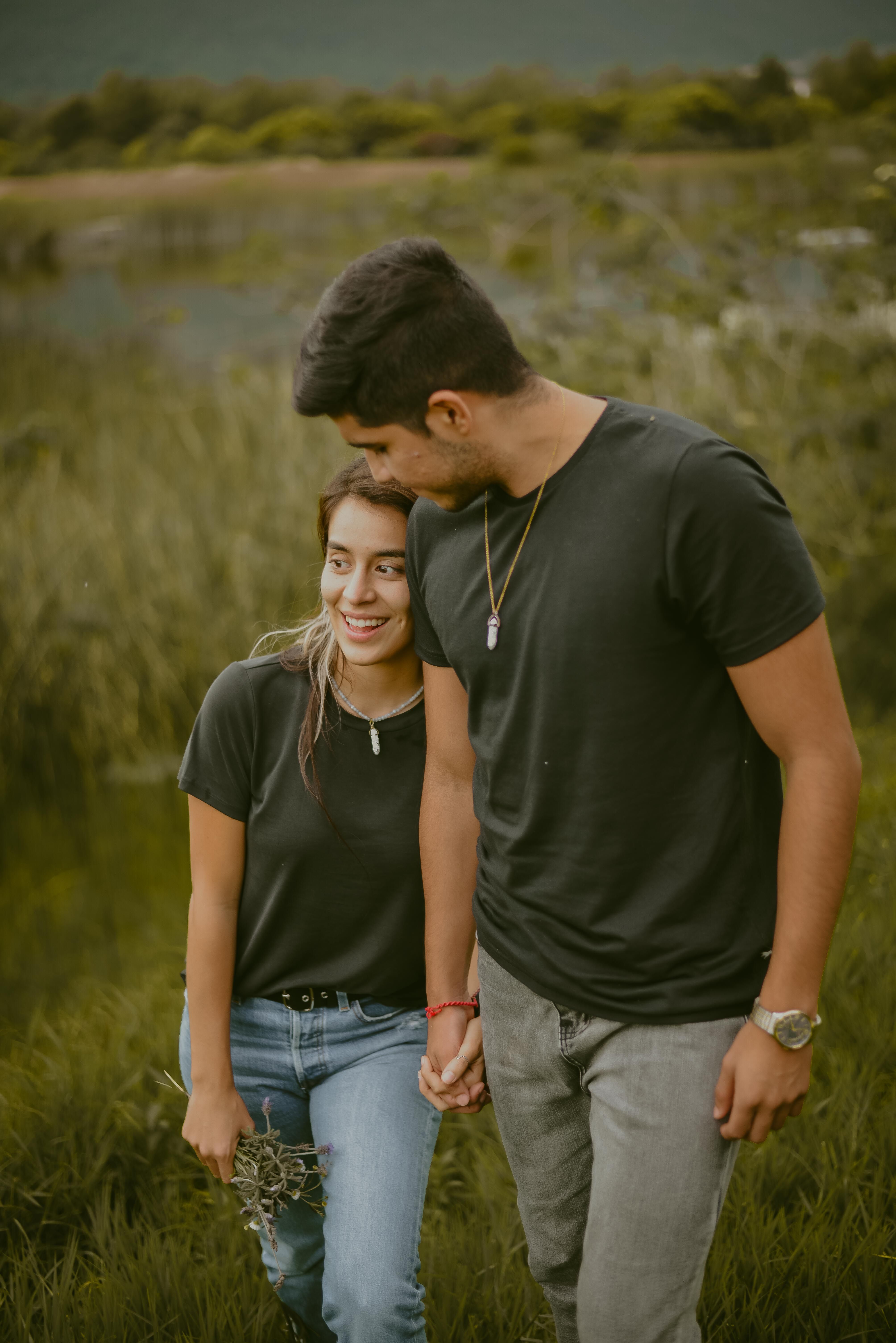 Couple Holding Hands while Standing on Green Grass · Free Stock Photo