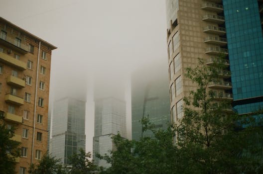 现代摩天大楼笼罩在雾中，为城市景观增添了一抹神秘的氛围