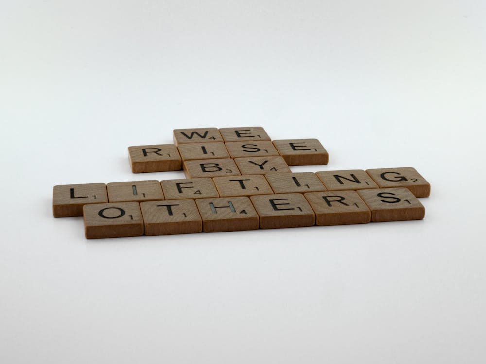 Wooden Scrabble Tiles on White Surface - Empowering Women Girls Outdoors