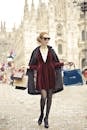 一位时尚女士提着购物袋走过米兰大教堂，尽显都市风格