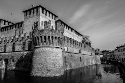 Grayscale Photography of Castle Near Body of Water