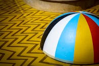 一件几何艺术作品明亮多彩，表面饰有锯齿形图案，顶部是一个条纹圆顶