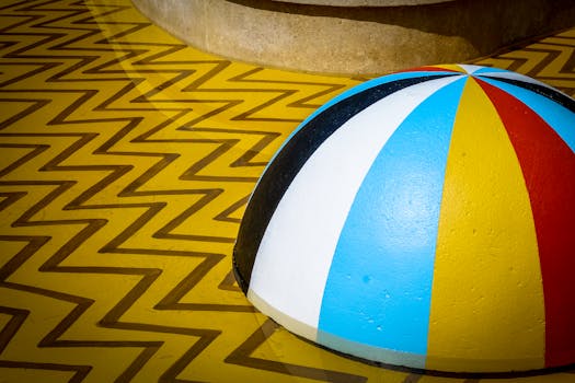 一件几何艺术作品明亮多彩，表面饰有锯齿形图案，顶部是一个条纹圆顶