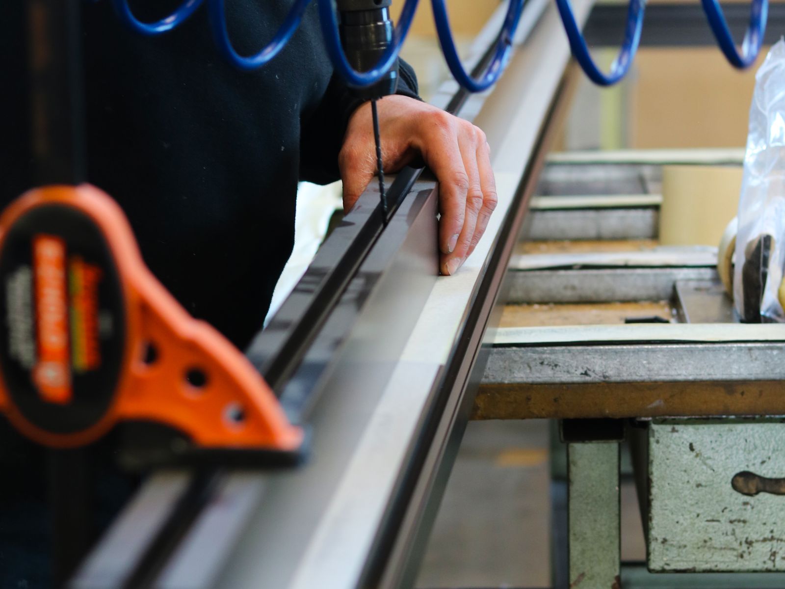 Aluminium profile being measured and cut on the factory floor