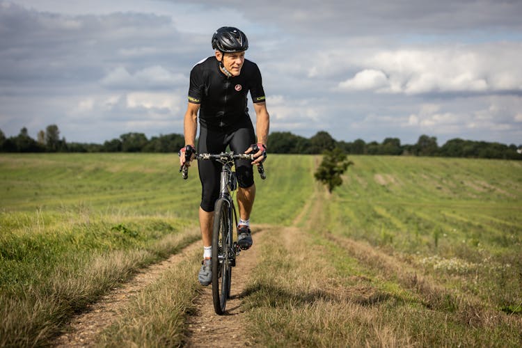 Adult Man Cycling On Rural Road