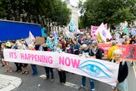 Demonstration of people wearing masks with placards and banners