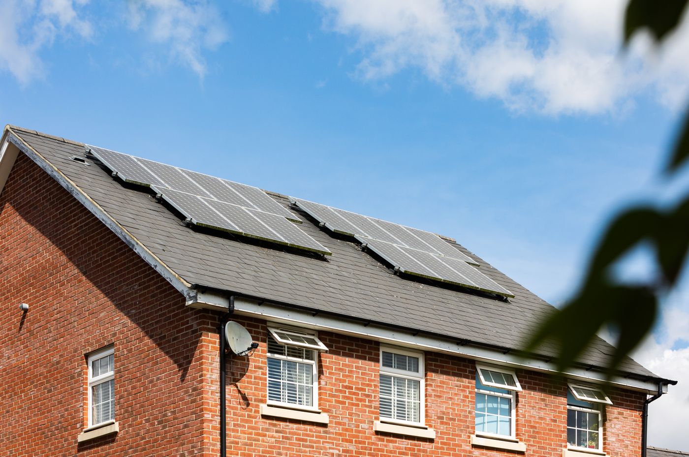 Woning met zonnepanelen op het dak onder een blauwe lucht