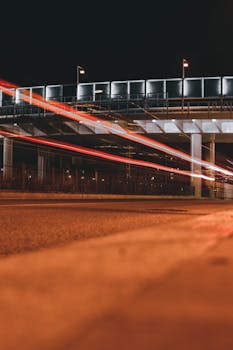 A nighttime long exposure capturing light trails on a bridge in Barcelona, Spain.