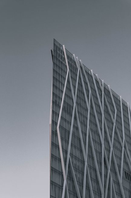 Explore the futuristic design of a modern skyscraper with a striking glass facade in Barcelona, Spain.