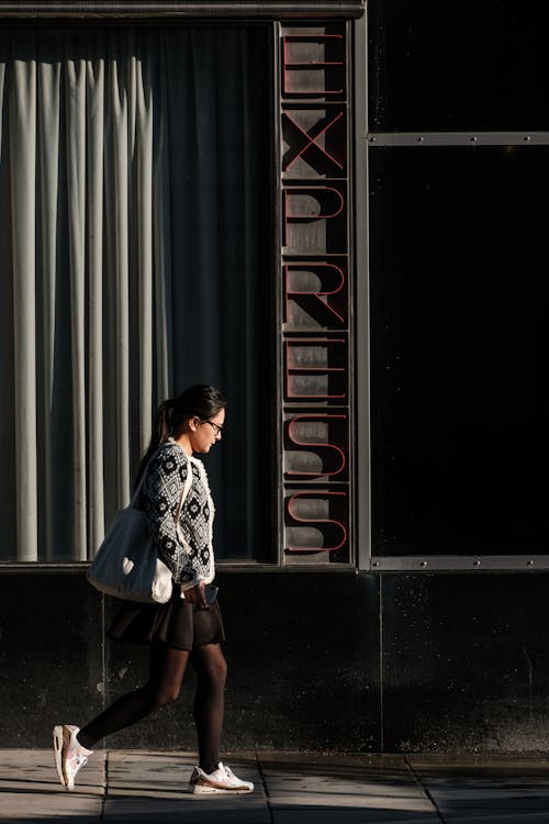 Side View of a Woman Walking on the Street 