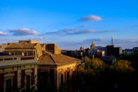 意大利城市屋顶、树木和教堂圆顶在蓝天下呈现迷人的日落景观