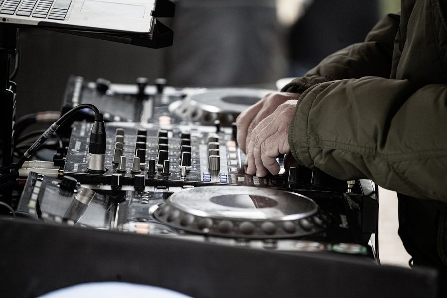Fotografía representativa de un DJ utilizando una consola de sonido