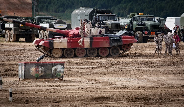 Soldiers On Military Machines On Mud Field