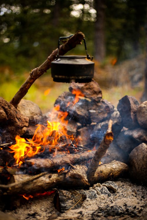 Camping kettle over burning campfire. Stock Photo