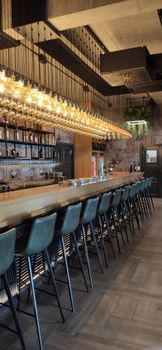 A chic and modern bar interior with elegant lighting and seating arrangement.