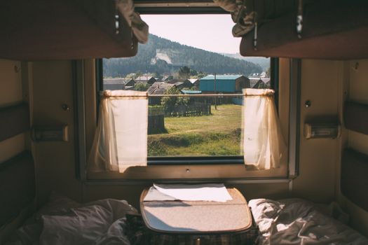 View from a train window overlooking a charming village landscape.