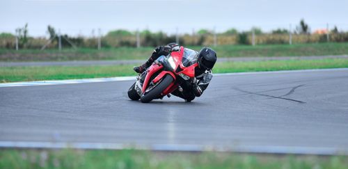 Free Motorcyclist wearing a helmet leans into a turn on a race track. Stock Photo