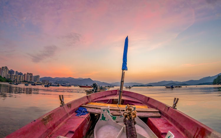 Red Boat On Body Of Water With Blue Flag