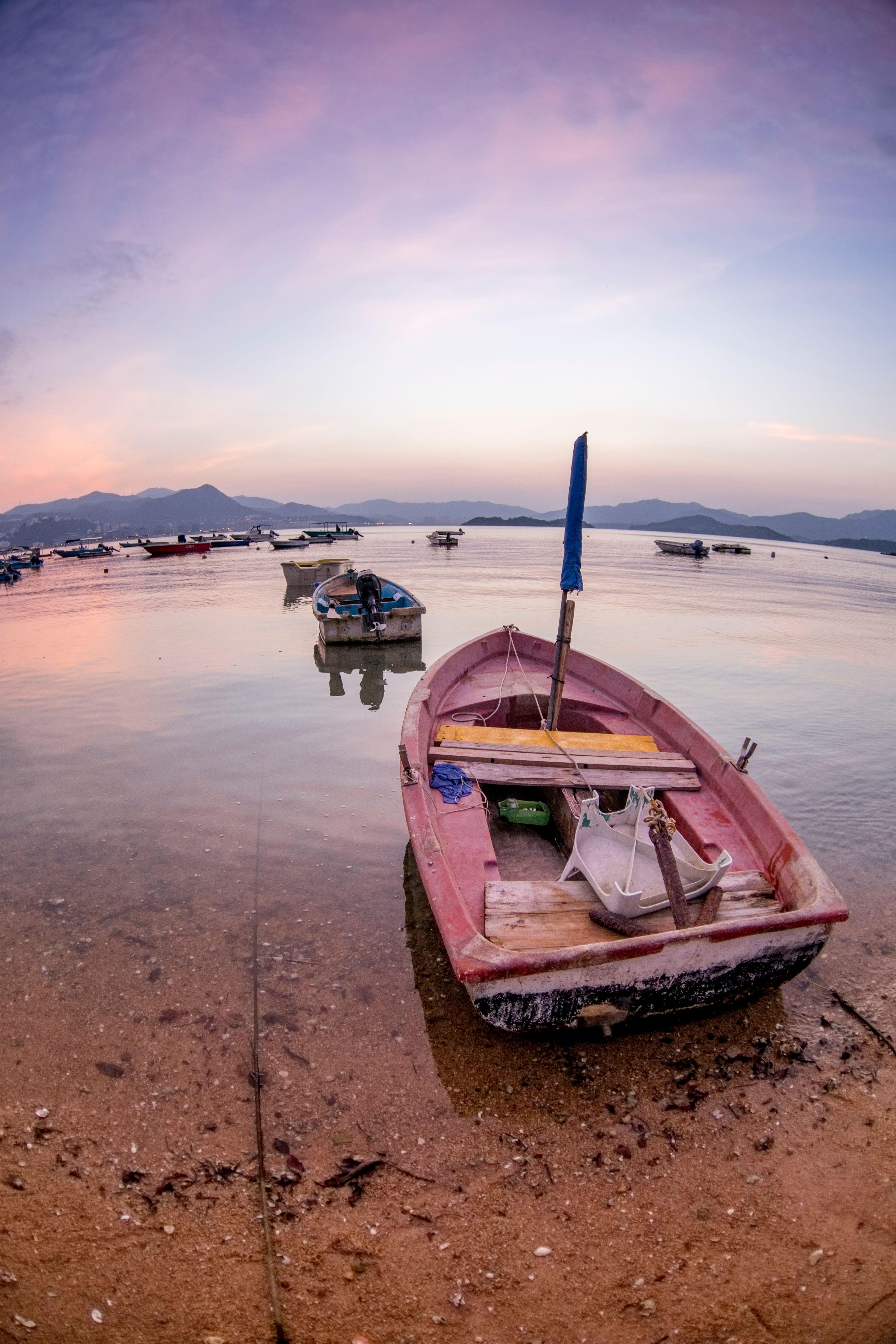 A serene sunset view featuring boats on the calm waters near Kowloon, Hong Kong.