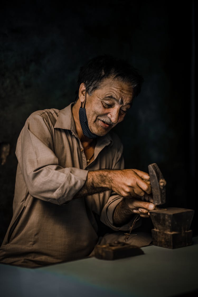 An Elderly Man Holding A Hammer