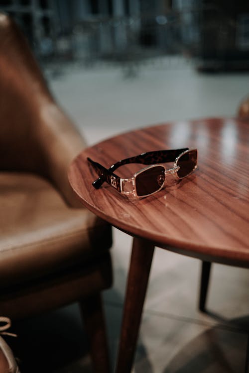 Free Black Sunglasses on Brown Wooden Table Stock Photo