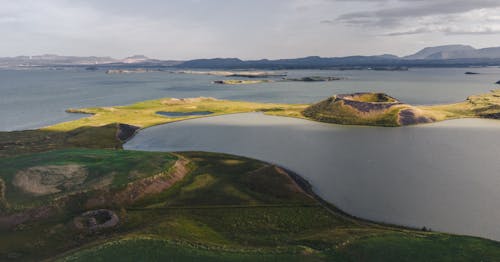 Green Grass Field Near Body of Water