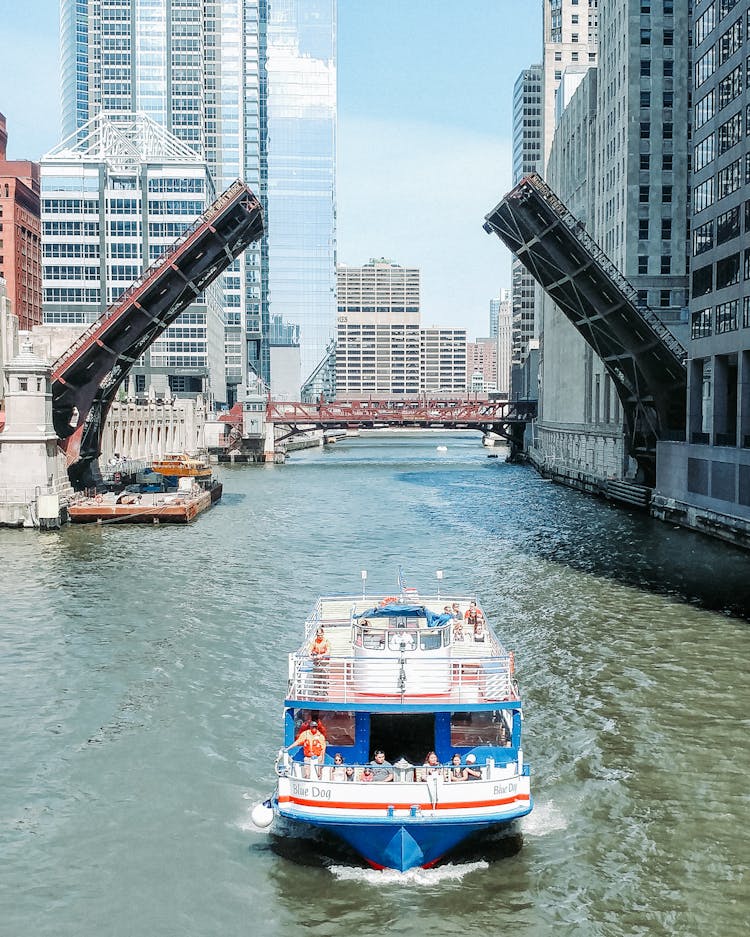 Ferryboat Cruising On A River Between City Building