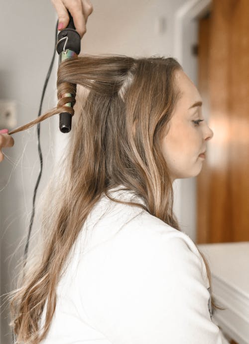 Free Woman Curling Her Hair Stock Photo