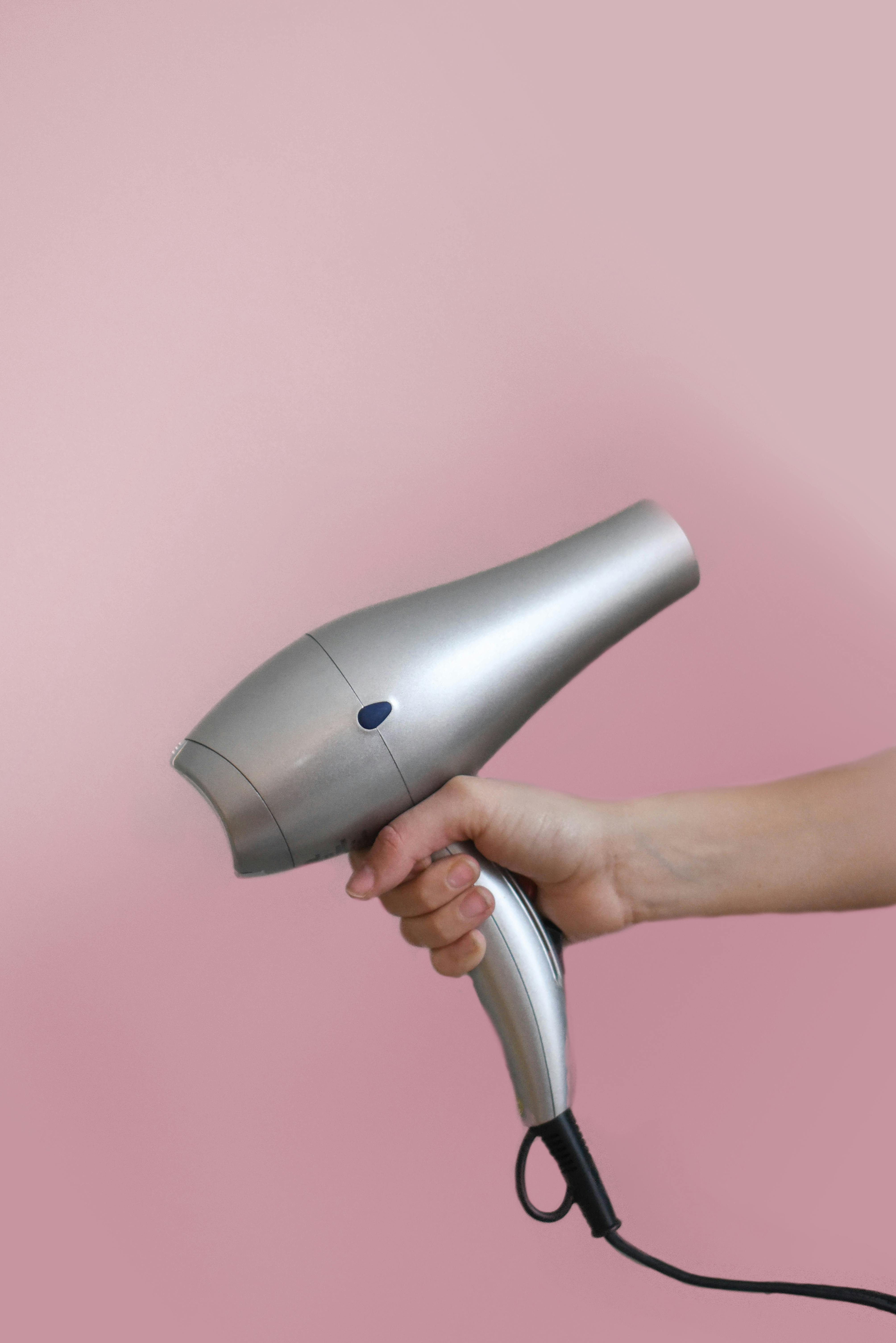 Person Holding Grey Hair Dryer · Free Stock Photo