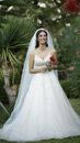 Woman in White Wedding Dress Holding a Red Flower
