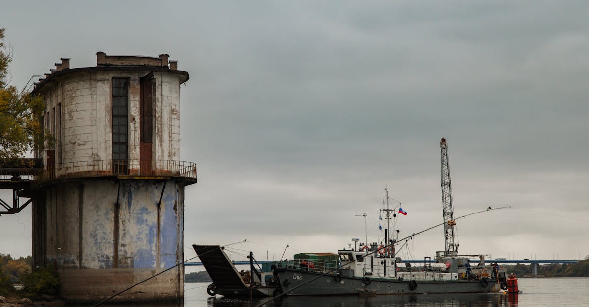 Industrial vessel docked by an old structure in a harbor with a gloomy sky.