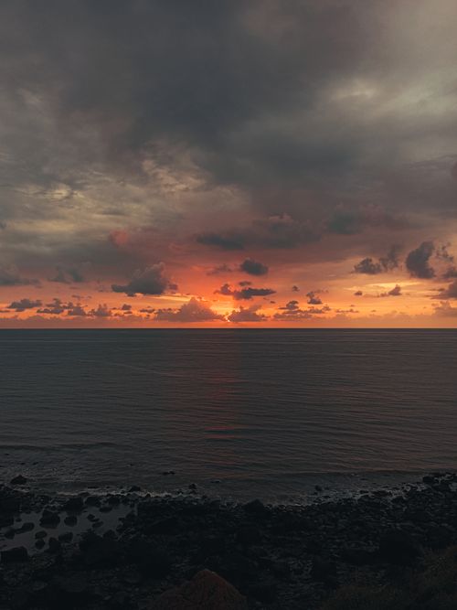 Free Serene seascape at sunset with calm waters and dramatic clouds, perfect for tranquil views. Stock Photo
