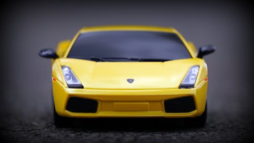 Free Bright yellow miniature sports car captured in front view, showcasing sleek design. Stock Photo