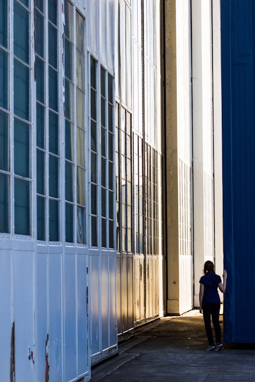 Back View of a Woman Between Walls of High Rise Buildings