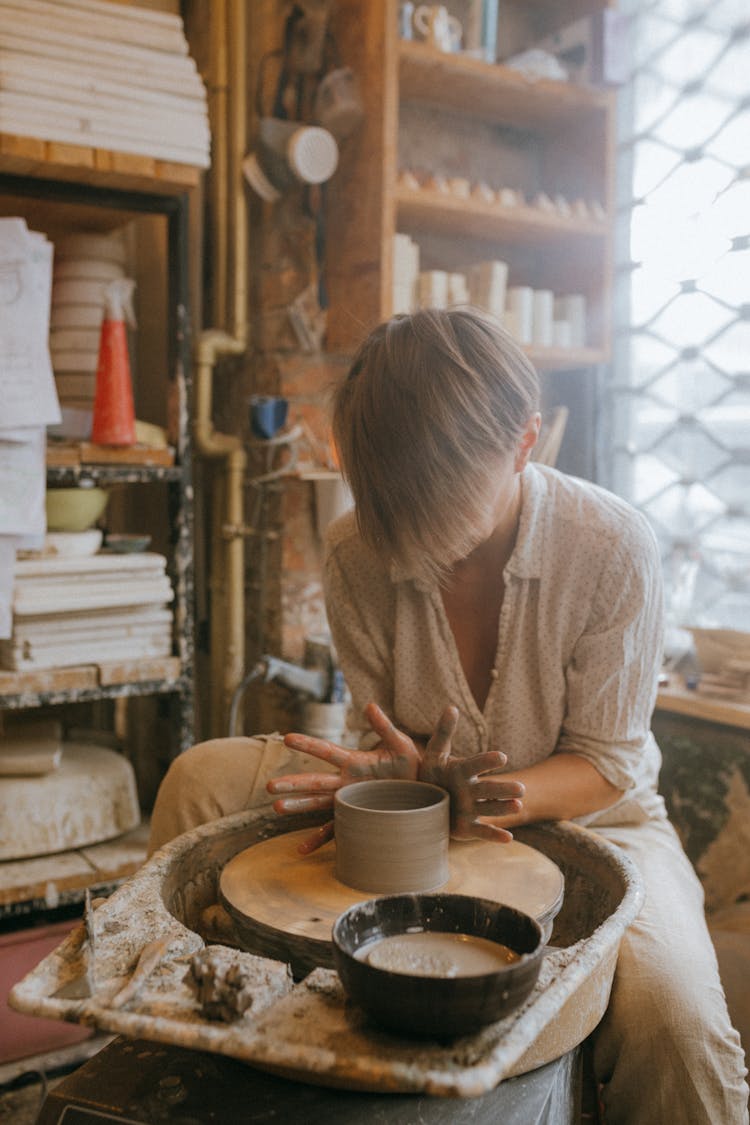 Woman Molding Clay On A Pottery Wheel