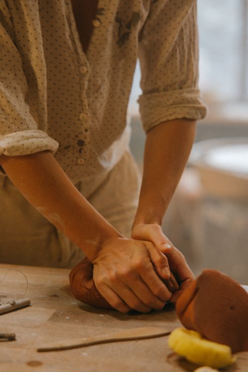Free Focused artisan kneading clay, showcasing pottery skills in an indoor workshop setting. Stock Photo