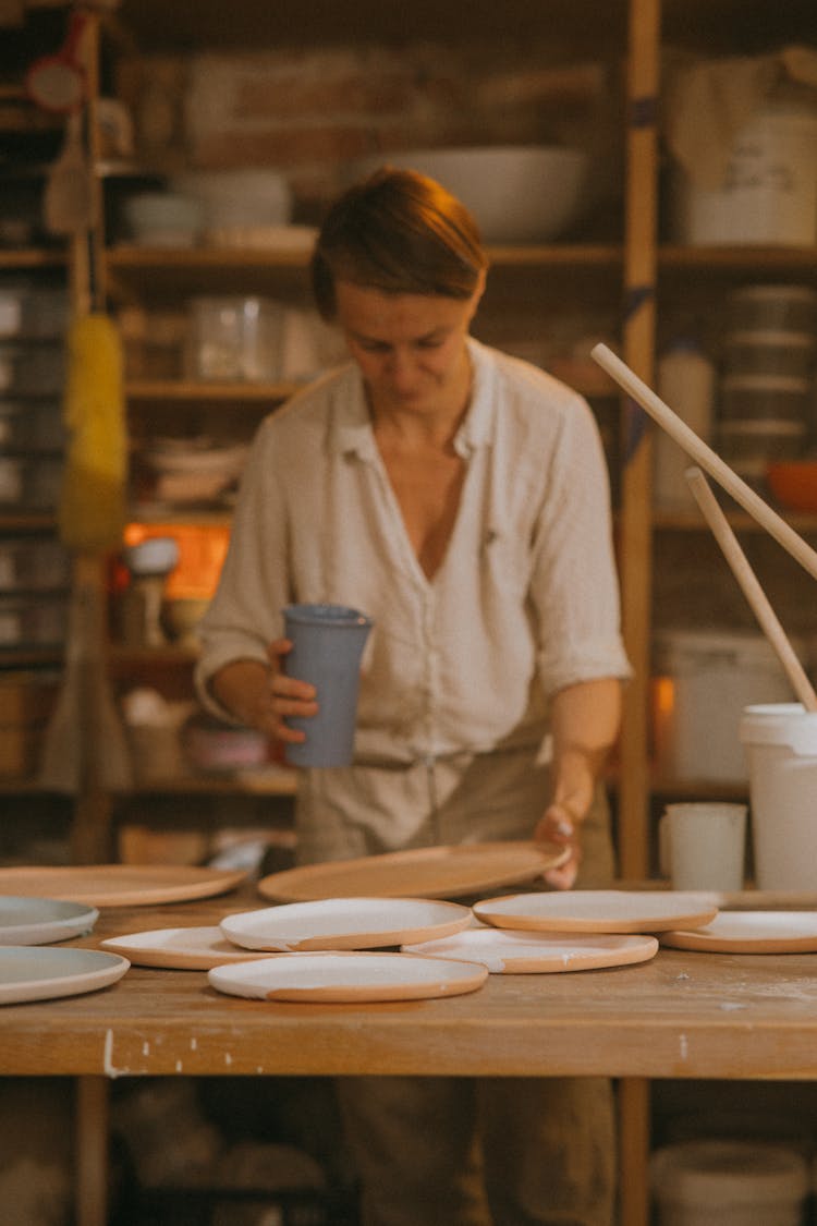 An Artist Glazing Ceramic Plates