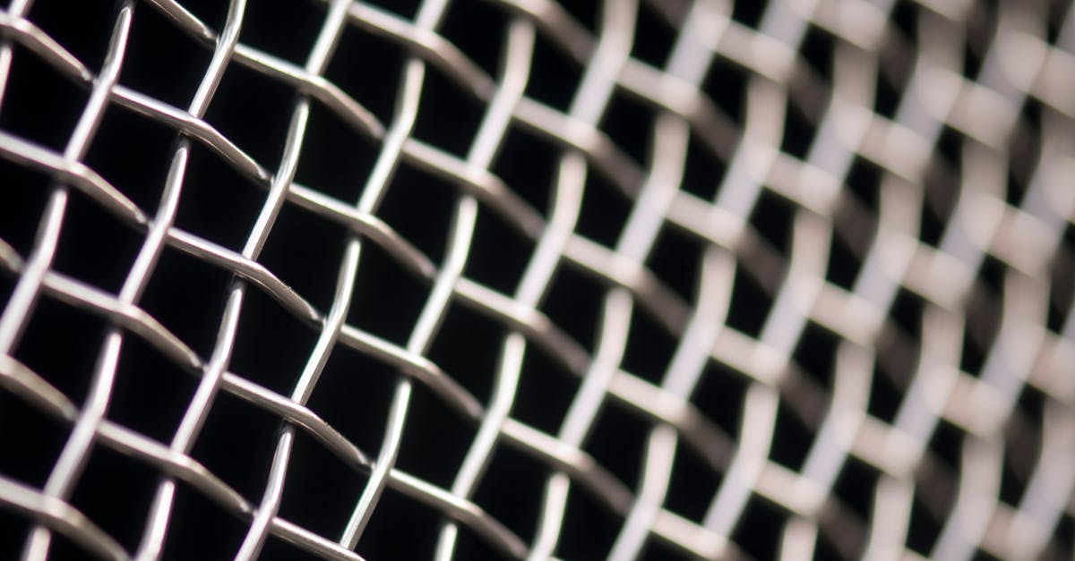 Detailed closeup of metal wire mesh pattern with a blurred background, showcasing texture and structure