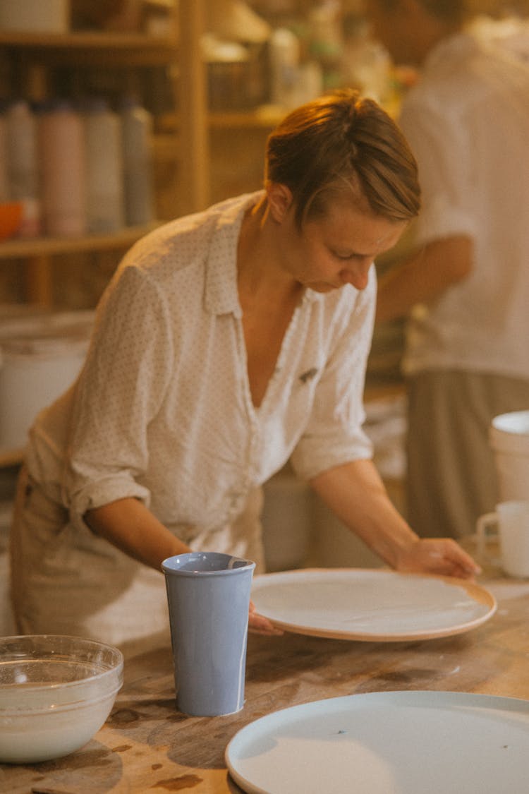 An Artist Glazing A Ceramic Plate