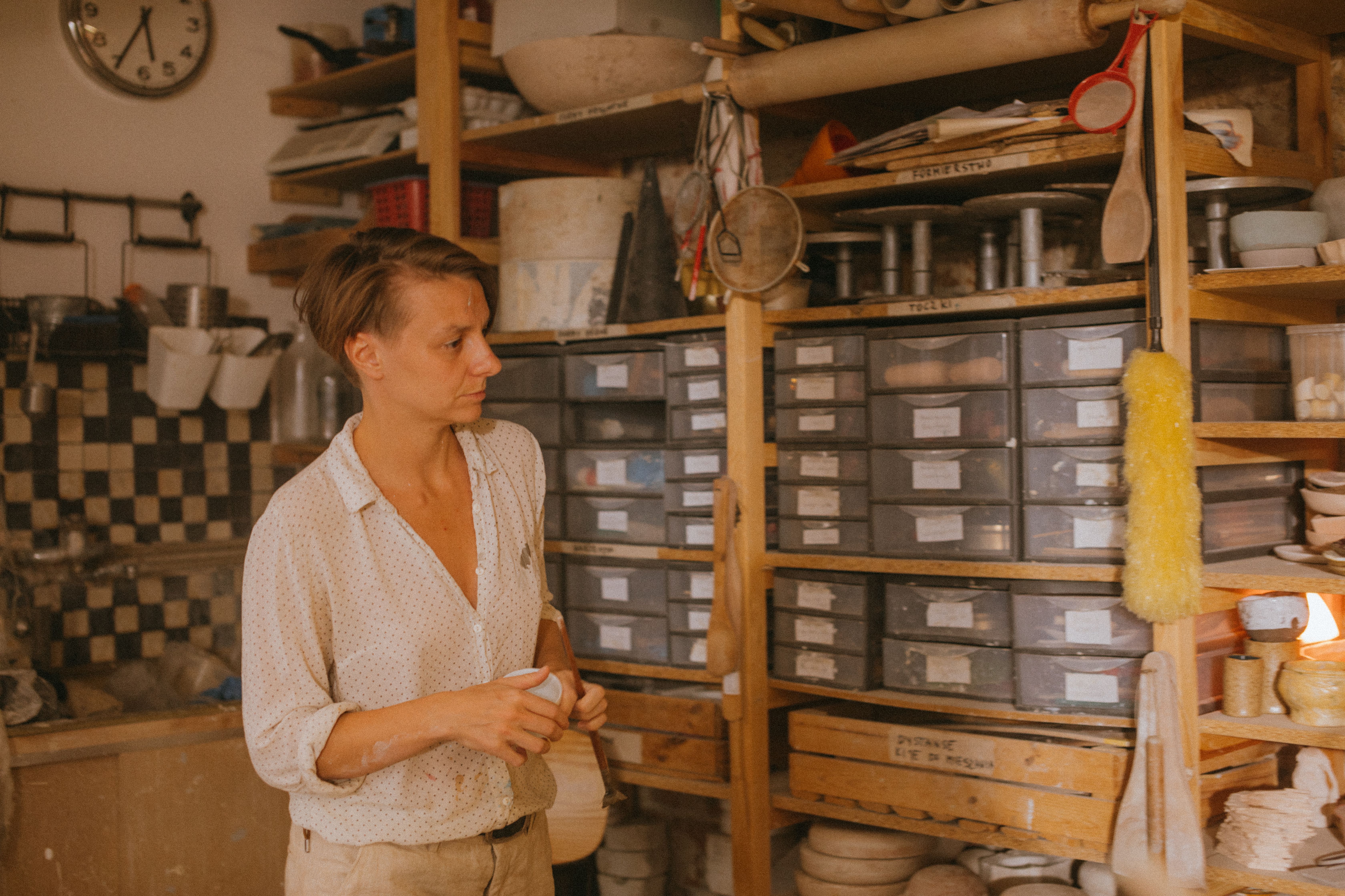 A pottery artist in a relaxed studio surrounded by clay and tools, evoking creativity.