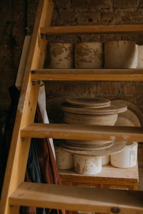 Free Rustic clay pots stacked on a wooden ladder in a cozy workshop setting. Stock Photo
