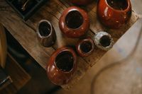 Small pots in a deep iron-red glaze — photo by KoolShooters on Pexels