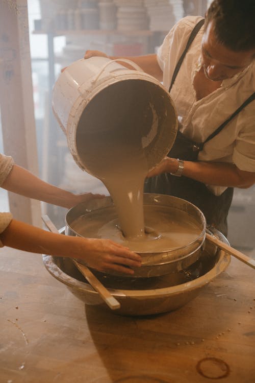 Craftsman pouring Clay Liquid on a Sieve 