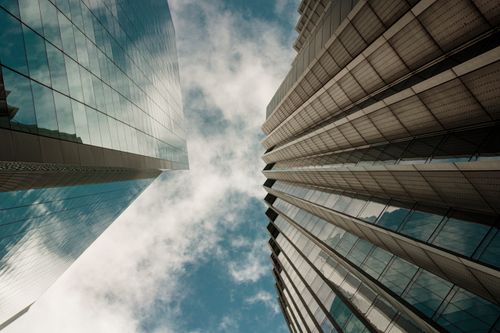 Free Low-angle view of modern skyscrapers in London with glass exteriors against a cloudy sky. Stock Photo