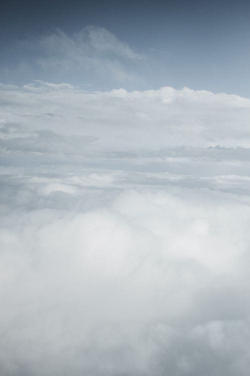Free Peaceful cloudscape with soft, fluffy clouds stretching across the sky in a serene aerial view. Stock Photo