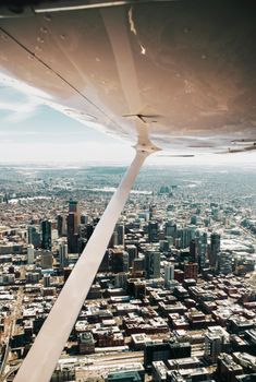 Stunning aerial view of a bustling downtown metropolis from an airplane's wing perspective.