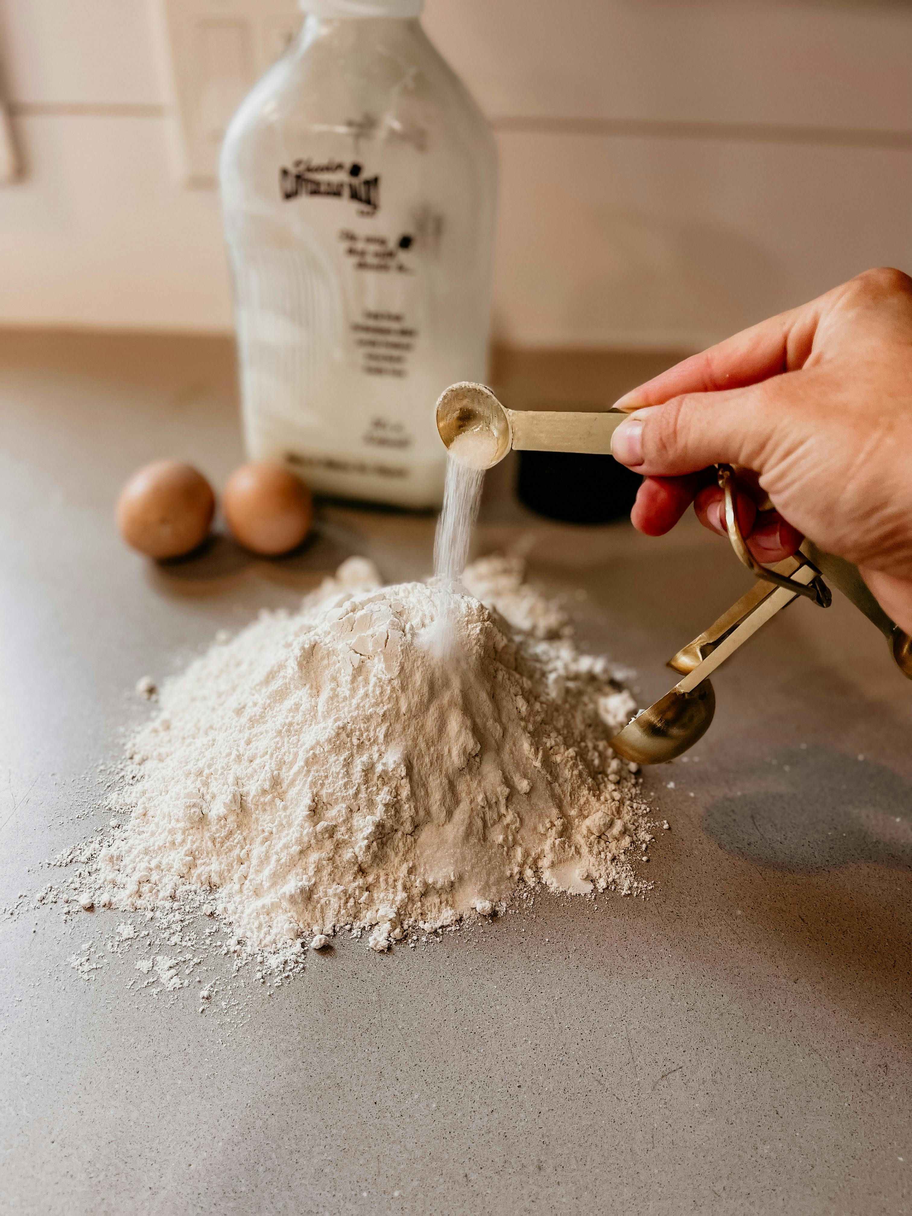 a person making a pile of dry ingredients for baking