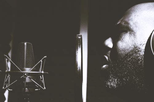 Free Side profile of a singer recording in a studio, black and white photo. Stock Photo
